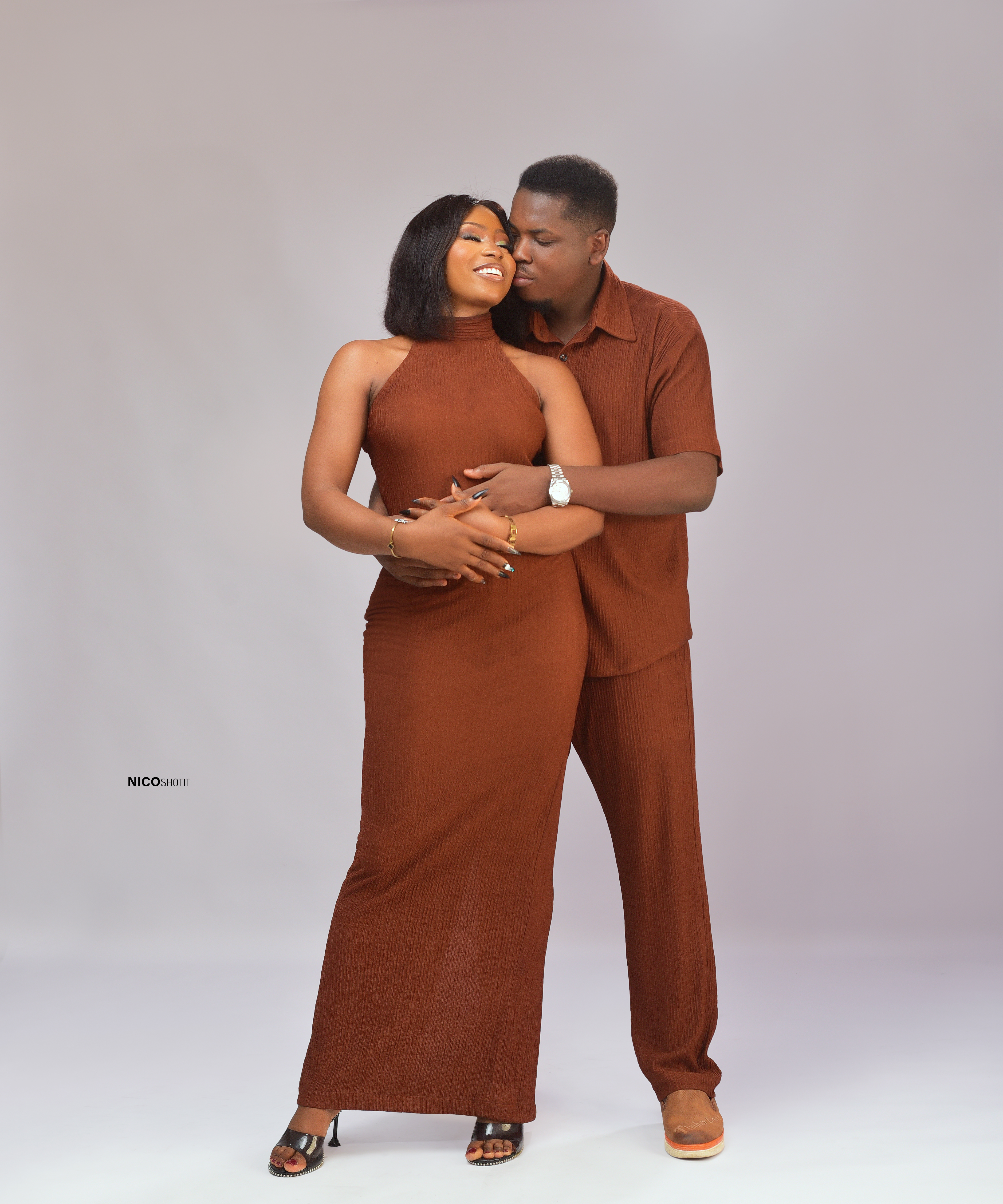 Chisom and Mmachukwu embracing lovingly in matching terracotta outfits
